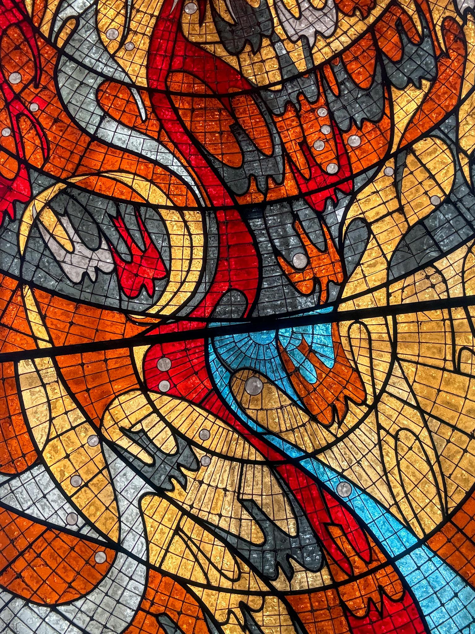 Dynamic stained glass mosaic pattern in vivid colors, showcasing intricate design.